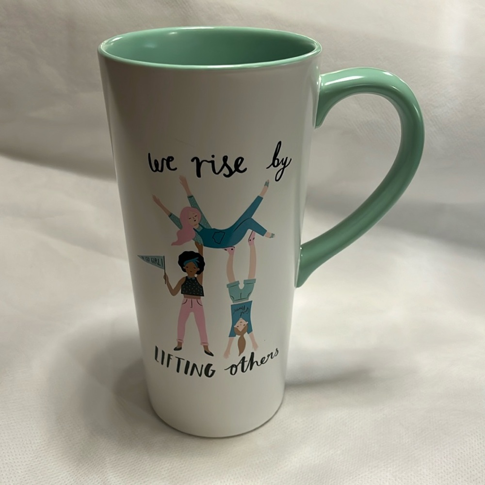 Tall ceramic mug “We rise by lifting others” for coffee or tea